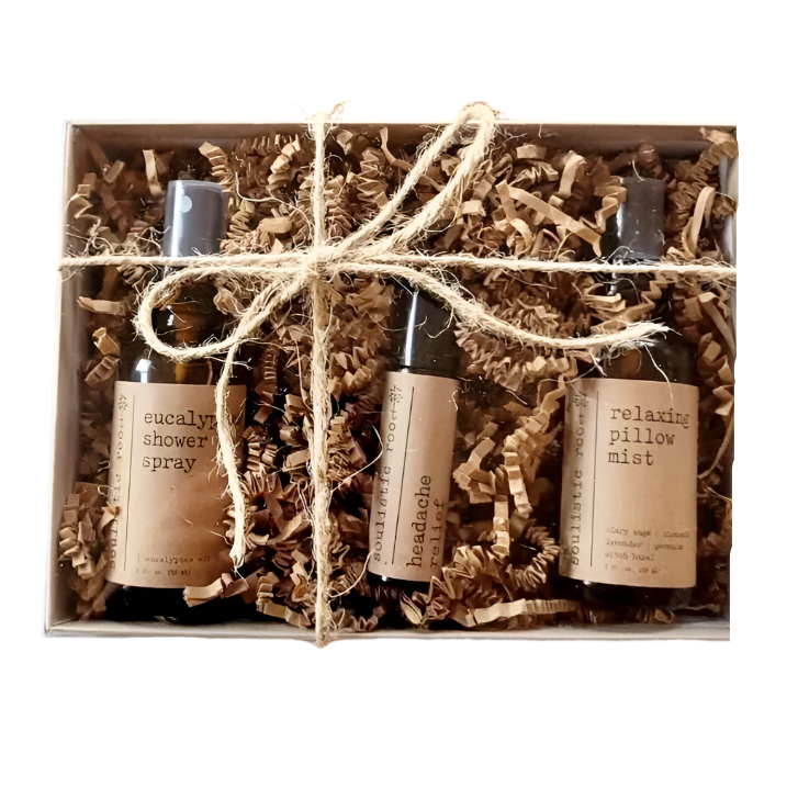 Set of three small bottles with labels in a box wrapped with string on a white background