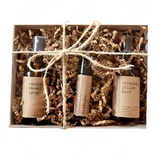 Set of three small bottles with labels in a box wrapped with string on a white background