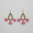 Pair of pink tassel earrings with gold accents on a light gray background