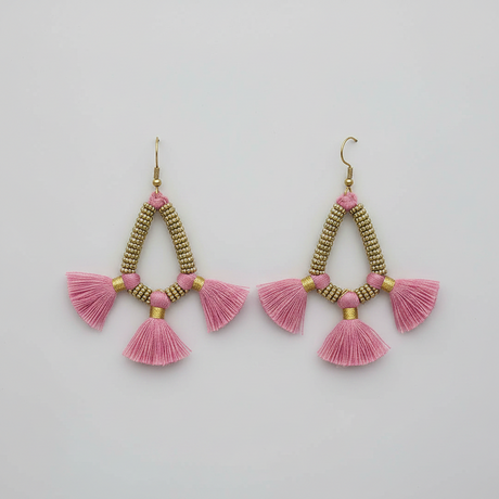 Pair of pink tassel earrings with gold accents on a light gray background