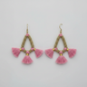 Pair of pink tassel earrings with gold accents on a light gray background