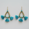 Pair of turquoise tassel earrings with gold accents on a light gray background