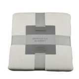 Folded Newcastle blanket with a label on a white background