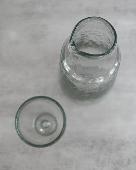 Two clear glass tumblers on a gray surface