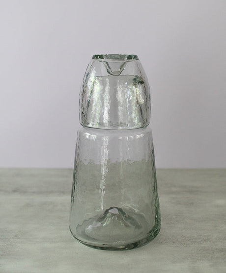 Clear glass vase on a light gray surface with a white background