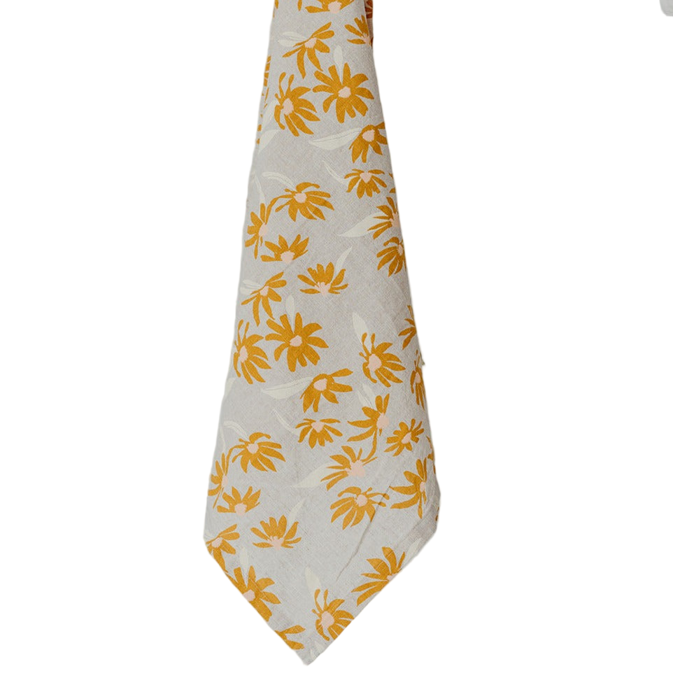 Hand holding a white towel with yellow floral pattern against a white background