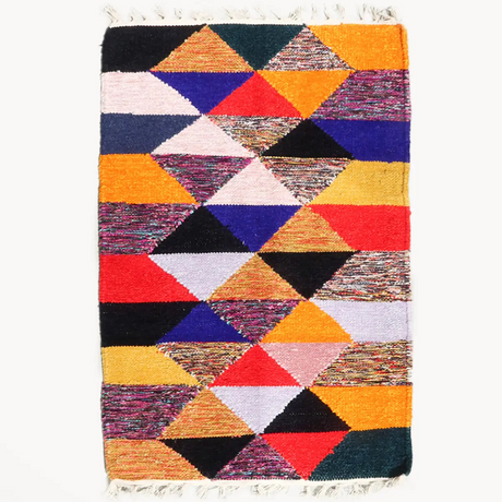 Multicolored geometric patterned rug on a white background