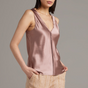 Woman wearing a pink satin tank top against a gray background