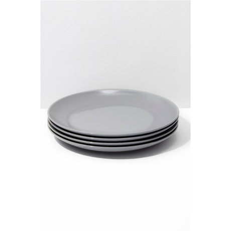 Set of four gray plates stacked on a white background