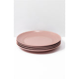 Set of four pink plates stacked on a white background