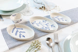 Dinnerware set with blue floral patterns on a striped tablecloth. Süheyla Nesting Plates