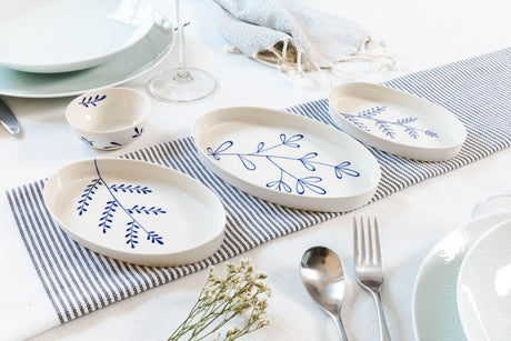 Dinnerware set with blue floral patterns on a striped tablecloth. Süheyla Nesting Plates