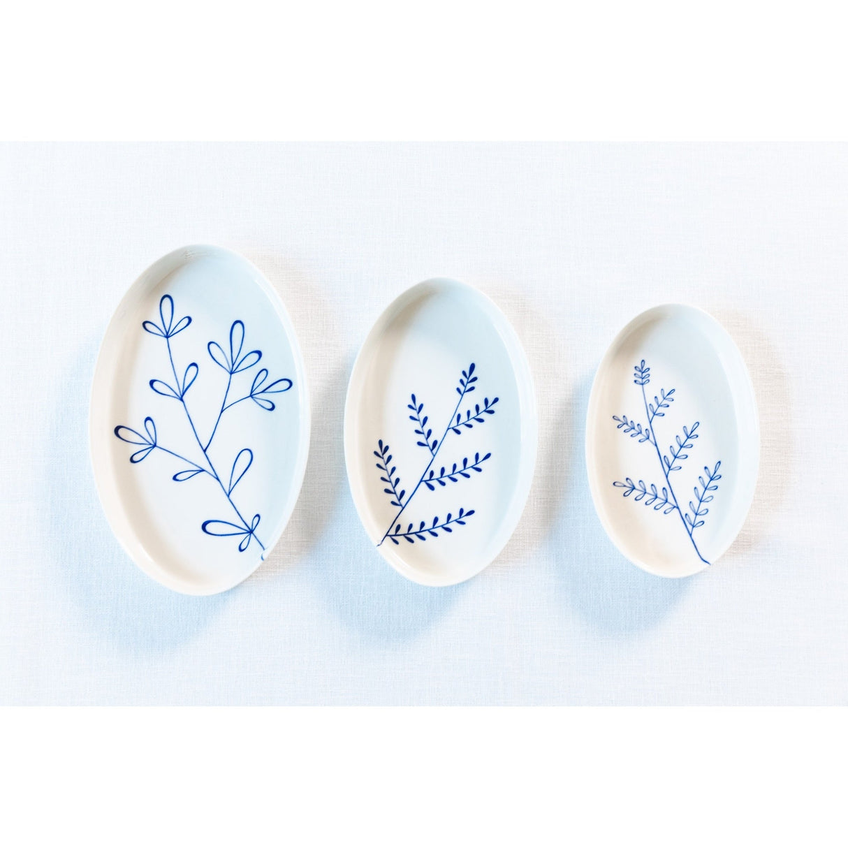 Three ceramic plates with blue floral patterns on a white background. Süheyla Nesting Plates