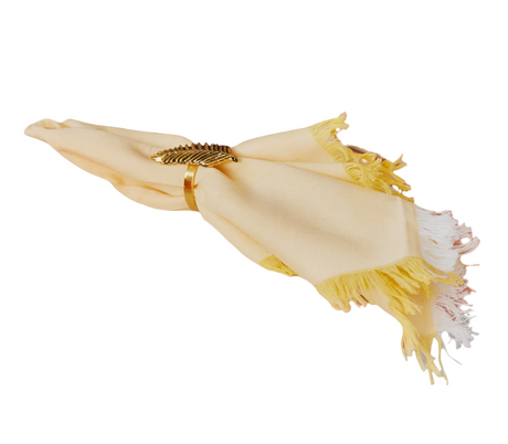 Decorative napkin with gold accent and tassels on a white background