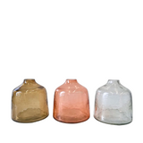 Three glass vases in clear, pink, and brown on a white background