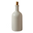 White ceramic bottle with cork stopper and two kiwis on a white background
