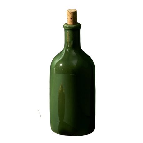 Green bottle with cork next to a lemon on a white background