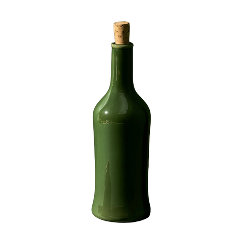 Green bottle with cork and garlic on a white background