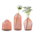 Set of three pink glass vases with flowers on a white background