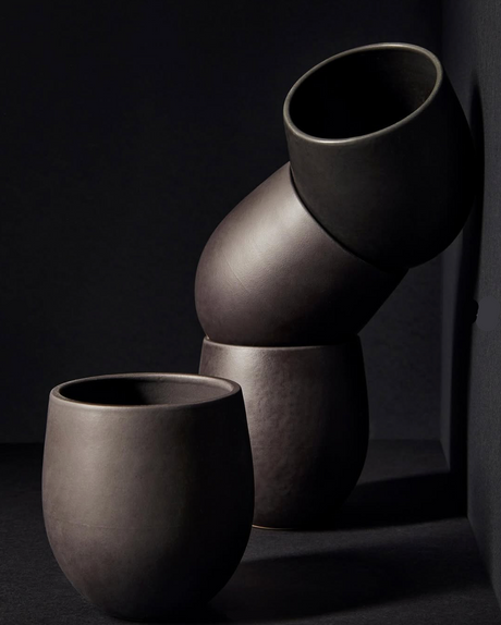 Set of dark gray ceramic vases on a black background