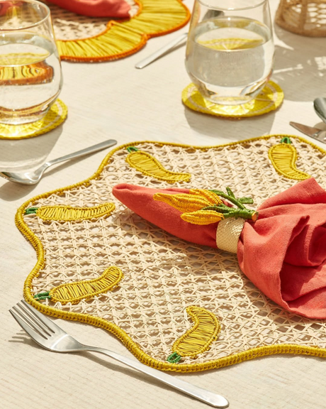 Decorative placemat with embroidered design on a table setting.