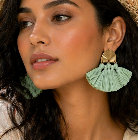 Woman wearing a straw hat and light clothing, sitting outdoors with flowers and food.