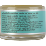 Jar of herbal cream with a label detailing its uses and ingredients.