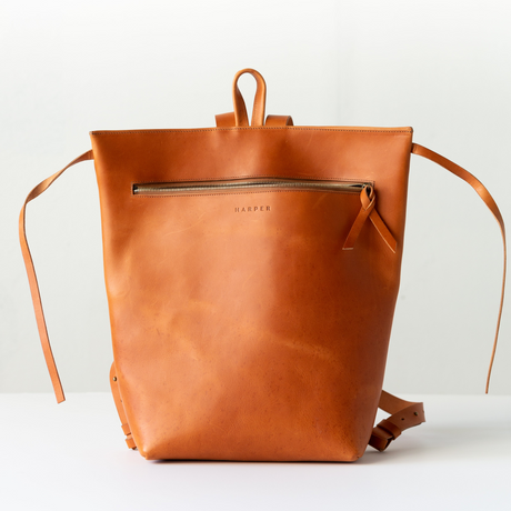 The Folded Backpack - Saddle. Brown leather backpack on a white background