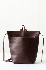 The Folded Backpack - Walnut. Brown leather backpack on a white background