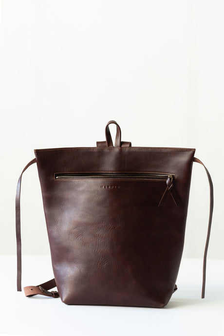 The Folded Backpack - Walnut. Brown leather backpack on a white background