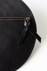 The Pleated Clutch - Black. Black leather pouch with a black ribbon on a white background
