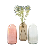 Three glass vases of different colors with a single stem of flowers on a white background