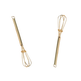 Two gold whisks on a white background