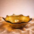 Glass bowl with a wavy edge on a beige fabric background