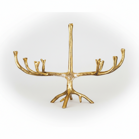 A gold menorah shaped like a stylized tree trunk with branching arms, shown against a plain white background.
