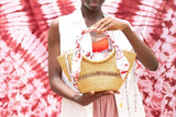 Woman holding a woven basket against a tie-dye background