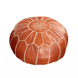 Brown leather pouf with geometric pattern on a textured surface