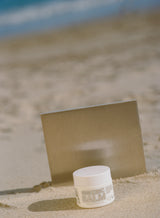 Jar of cream on sand with a blurred background
