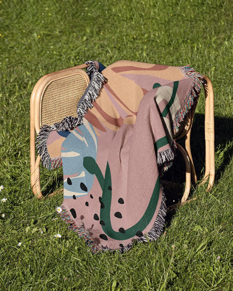 Abstract Garden Pink Cotton Woven Throw Blanket with a vibrant flower abstract design and fringe edges.