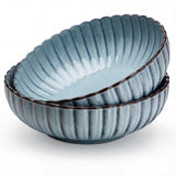 Set of three blue ceramic bowls with ribbed texture on a white background