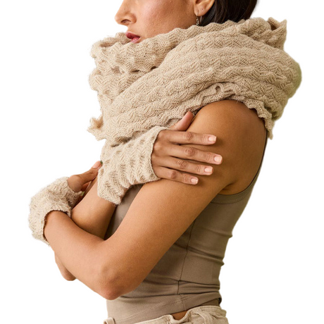 Woman wearing a beige knitted scarf and gloves on a white background