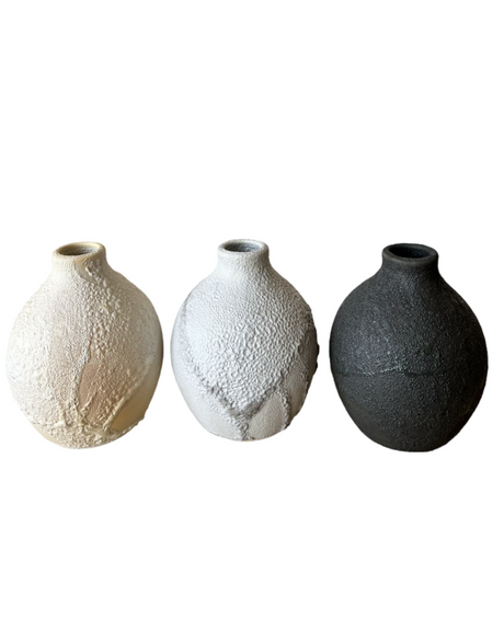 Three ceramic vases side by side, in beige, white, and black colors, each with a textured, frothy glaze.