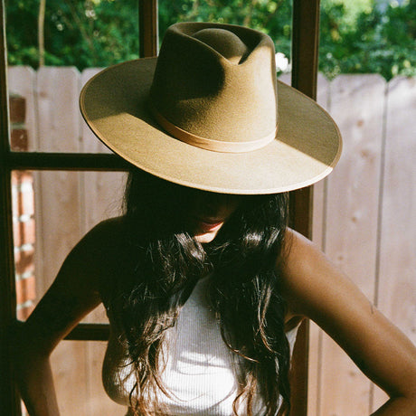 Person wearing a wide-brimmed hat with a blurred background