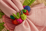 Close-up of a pink fabric with embroidered colorful vegetables on a textured background