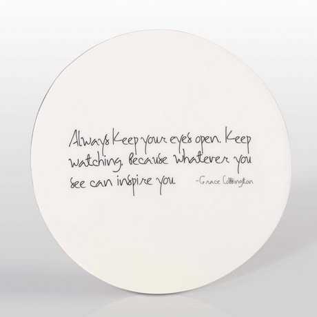 Round white plate with black text on a light gray background