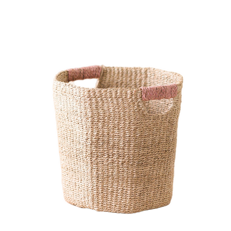 Woven basket with pink handle on a white background