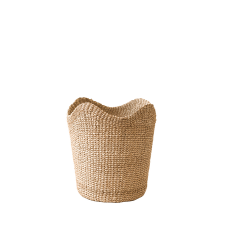 Woven basket next to books on a wooden surface with a beige background