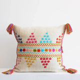 Decorative pillow with colorful patterns and tassels on a white background