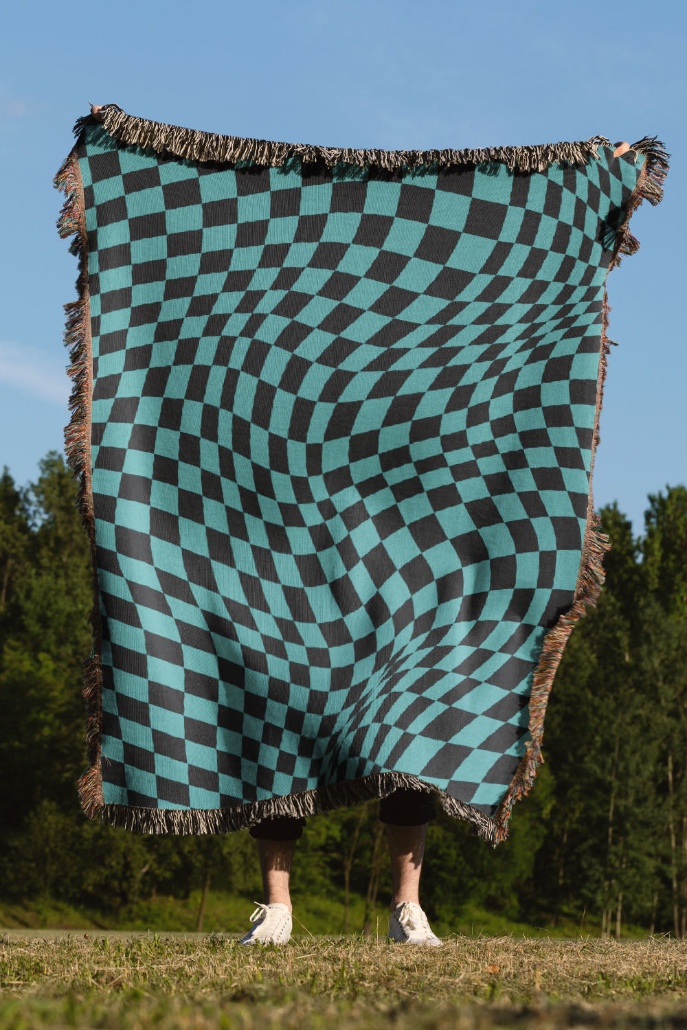 Black and blue wavy checkered woven throw blanket with a bold geometric pattern.
