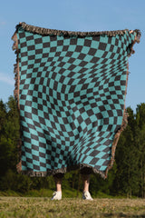 Black and blue wavy checkered woven throw blanket with a bold geometric pattern.

